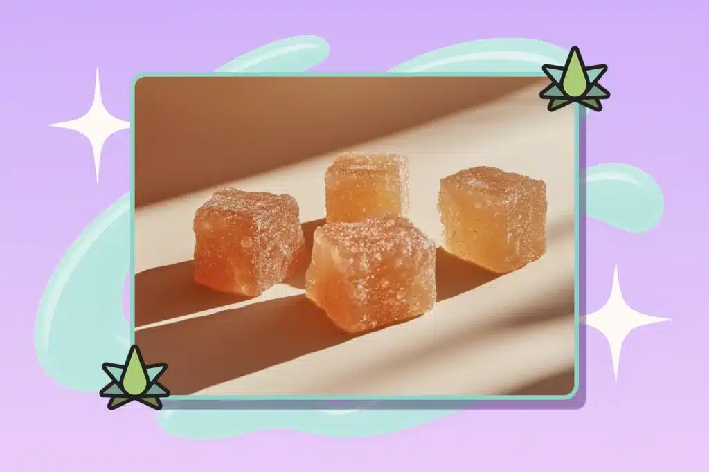 Four orange-colored gummies are on the floor with light shining on them