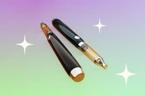Two black and gold vape pens are placed against a multicoloured background